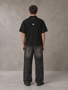 Model wearing the SM Shadow Pulse Shirt in Midnight Black, rear view.