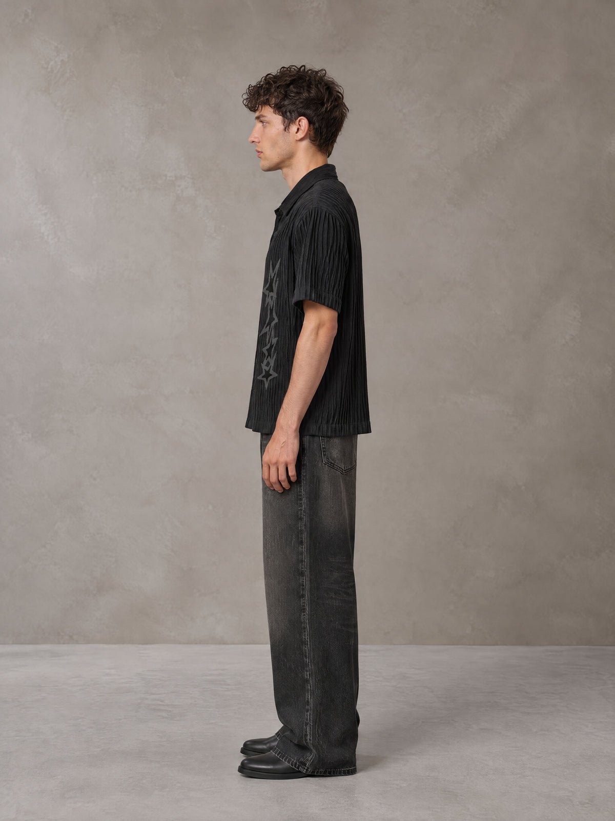 Model wearing the SM Shadow Pulse Shirt in Midnight Black, side profile.