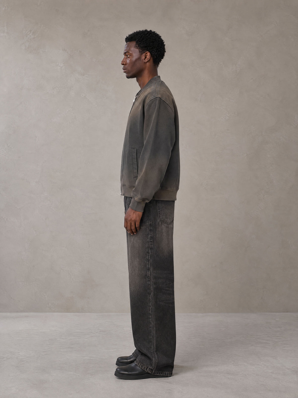 Model wearing the SM Sig. Shadow Fade Bomber Jacket in Ashen Grey, side profile.