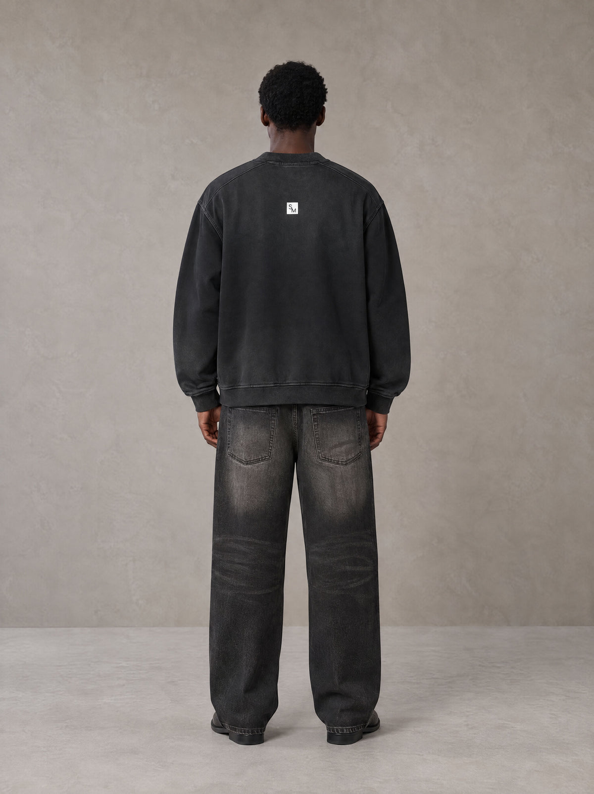 Model wearing the SM Sig. Shadow Fade Bomber Jacket in Midnight Black, rear view.