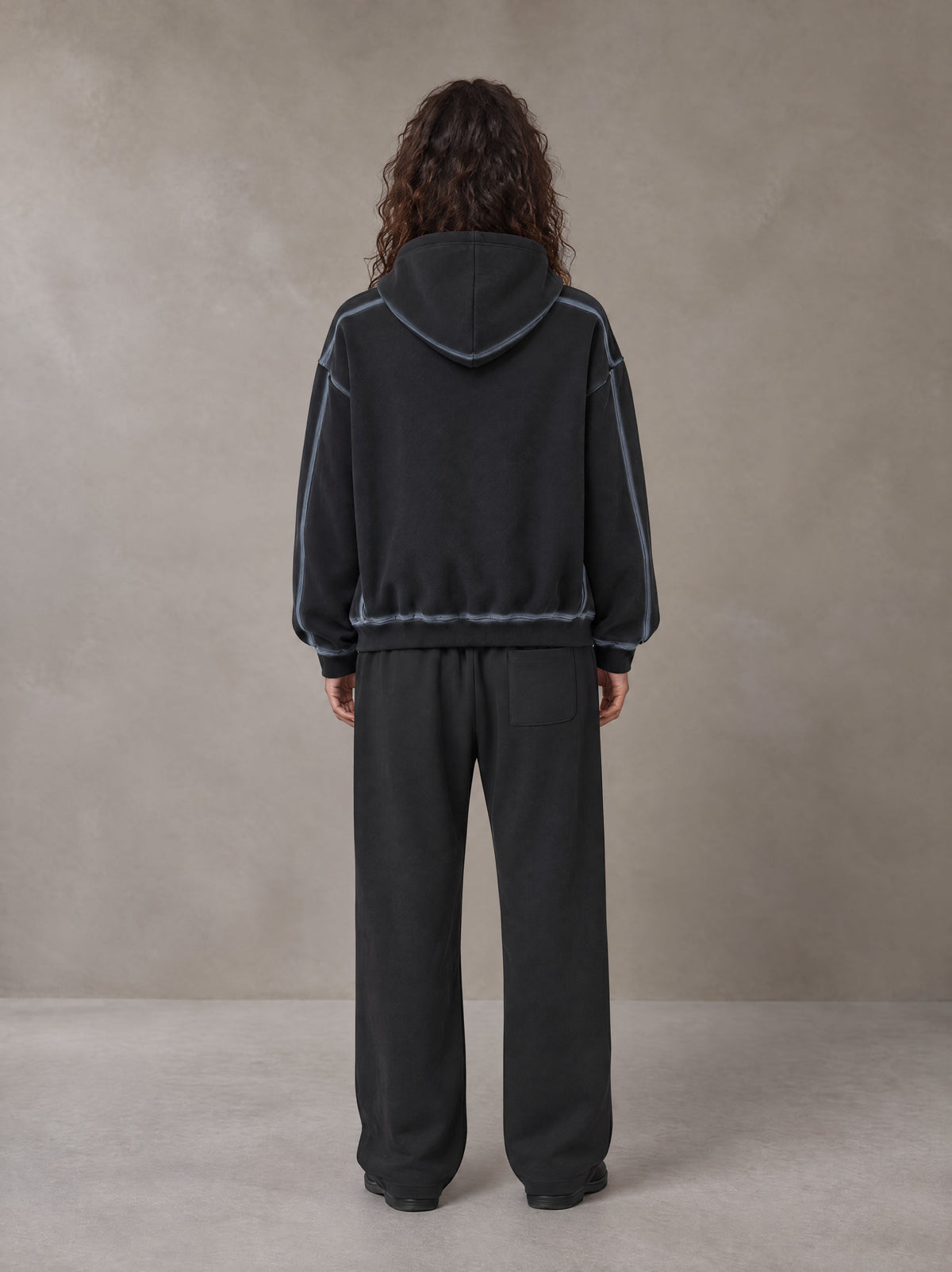 Model wearing the SM Sig. Straight Leg Sweatpants in Deep Charcoal, rear view.