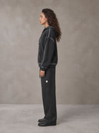 Model wearing the SM Sig. Straight Leg Sweatpants in Deep Charcoal, side profile.