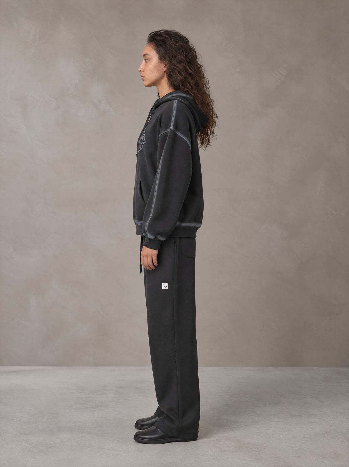 Model wearing the SM Sig. Straight Leg Sweatpants in Deep Charcoal, side profile.