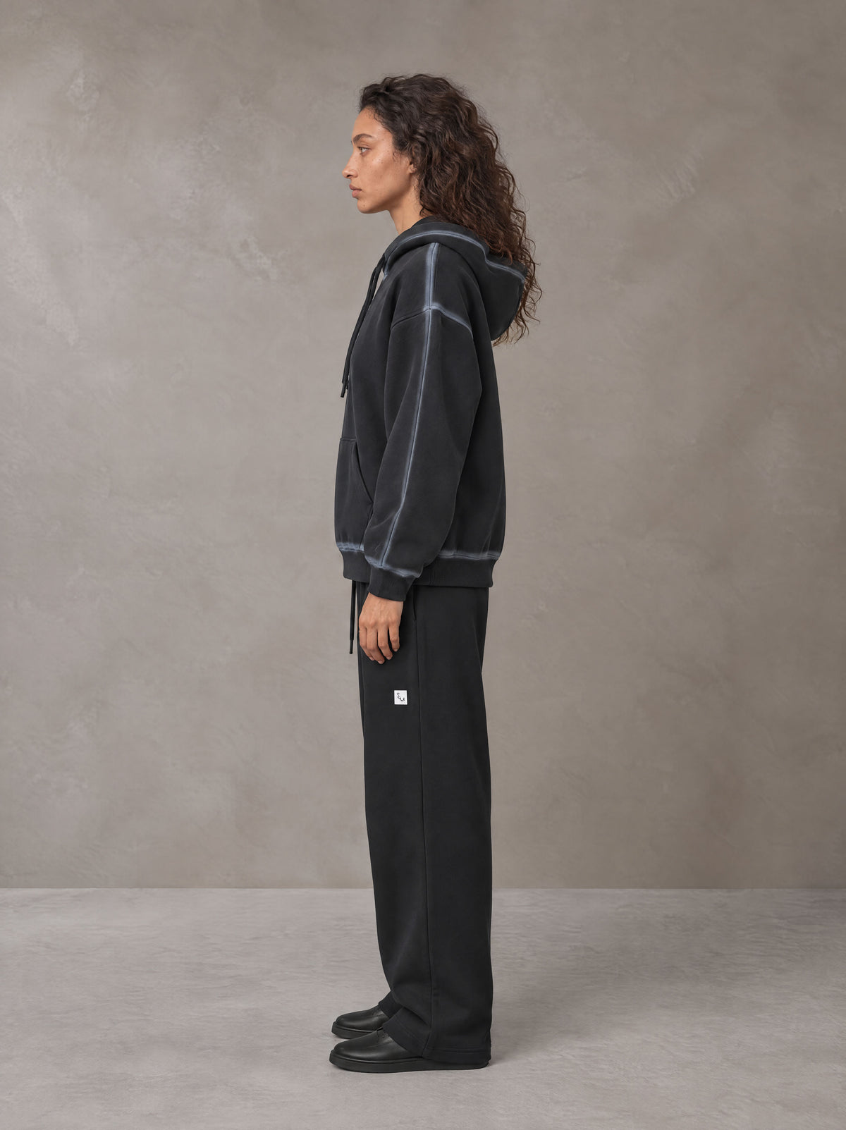 Model wearing the SM Sig. Straight Leg Sweatpants in Midnight Black, side profile.
