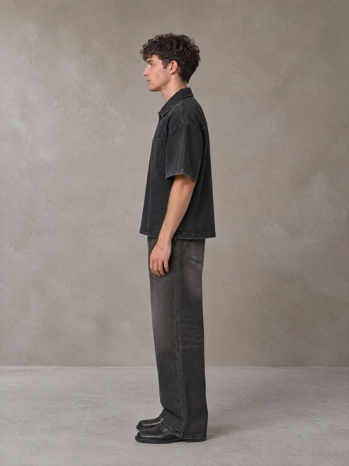 Model wearing the SM Shadowline Denim Zip T-shirt in Midnight Black, side profile.