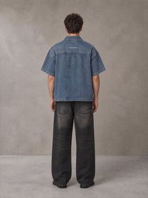 Model wearing the SM Shadowline Denim Zip T-shirt in Slate Blue, rear view.