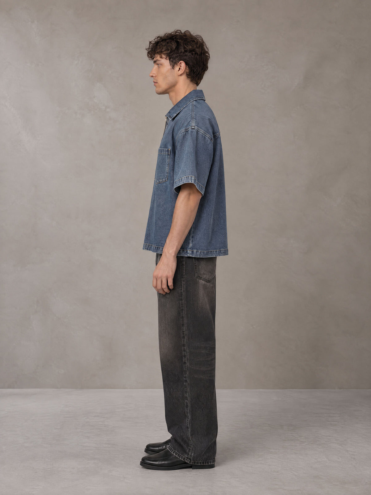 Model wearing the SM Shadowline Denim Zip T-shirt in Slate Blue, side profile.