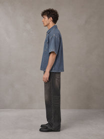 Model wearing the SM Shadowline Denim Zip T-shirt in Slate Blue, side profile.