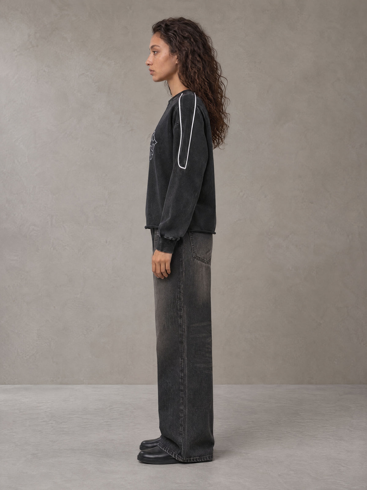 Model wearing the SM Fleur Eclipse Sweatshirt in Midnight Black, side profile.