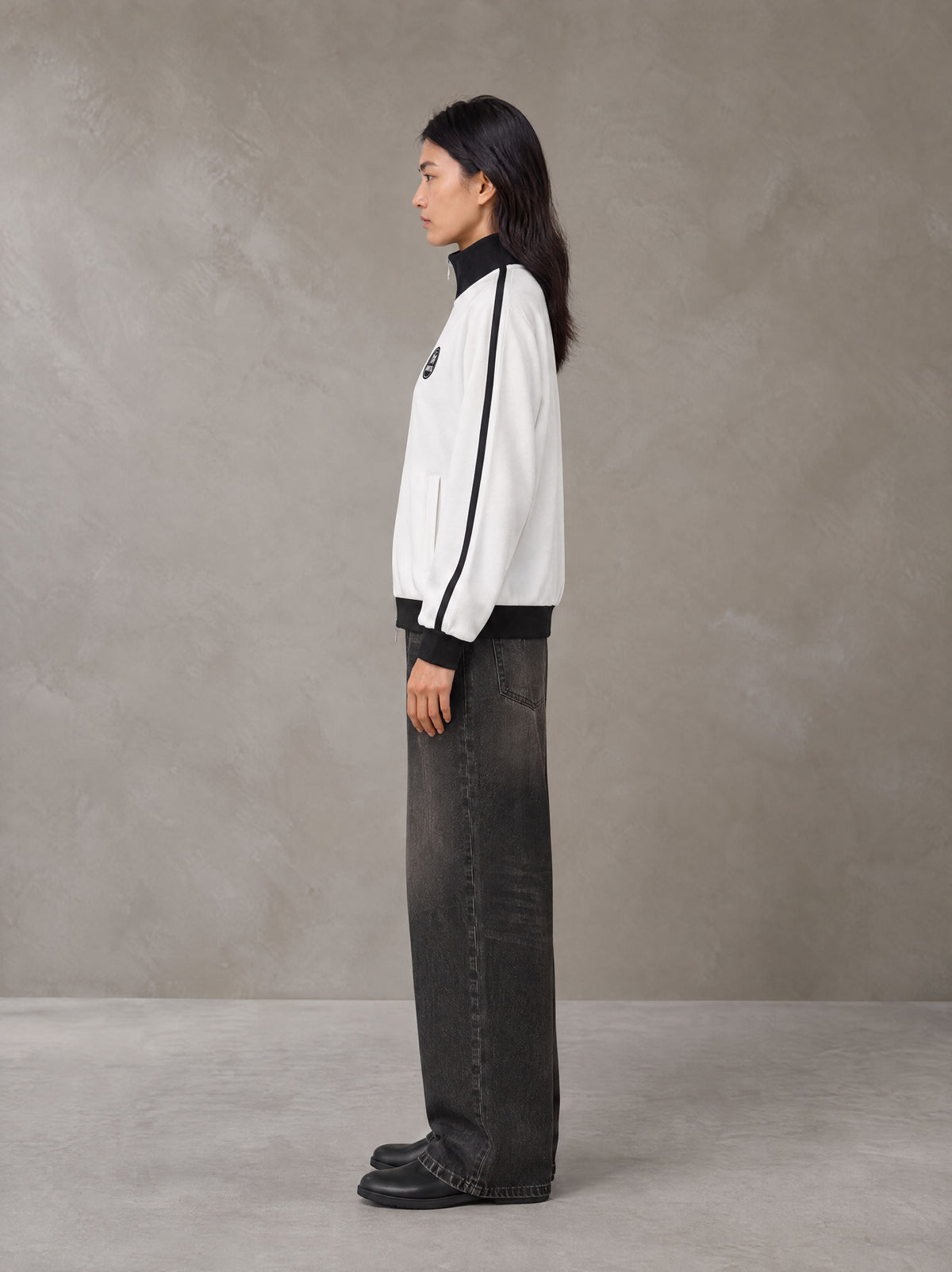 Model wearing the SM Insignia Contrast Trim Jacket in Lucent White, side profile.