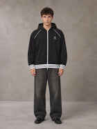 Model wearing the SM Insignia Hoodie in Midnight Black, front view.