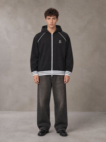 Model wearing the SM Insignia Hoodie in Midnight Black, front view.