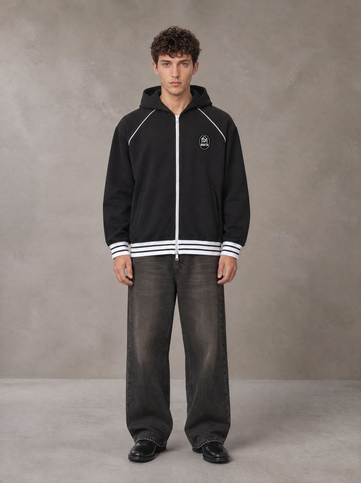 Model wearing the SM Insignia Hoodie in Midnight Black, front view.