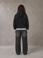 Model wearing the SM Insignia Hoodie in Midnight Black, rear view.