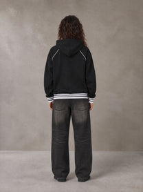 Model wearing the SM Insignia Hoodie in Midnight Black, rear view.