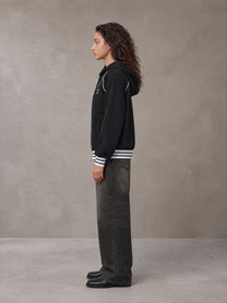 Model wearing the SM Insignia Hoodie in Midnight Black, side profile.