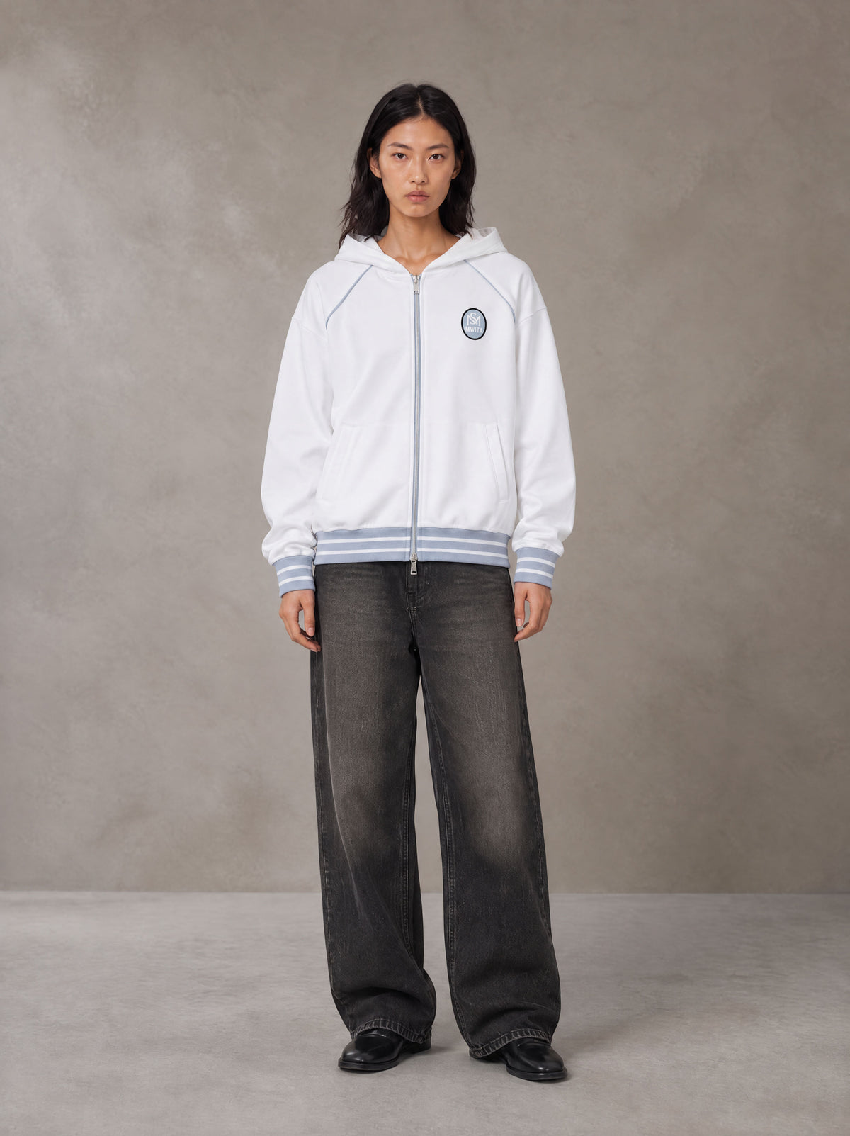 Model wearing the SM Insignia Hoodie in Lucent White, front view.