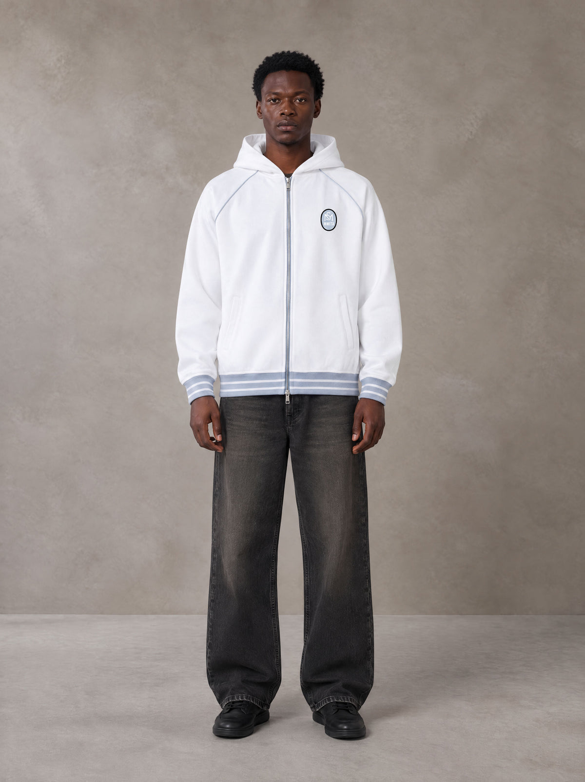 Model wearing the SM Insignia Hoodie in Lucent White, front view.