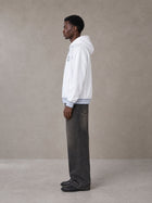 Model wearing the SM Insignia Hoodie in Lucent White, side profile.