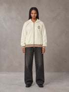 Model wearing the SM Insignia Hoodie in Soft Beige, front view.