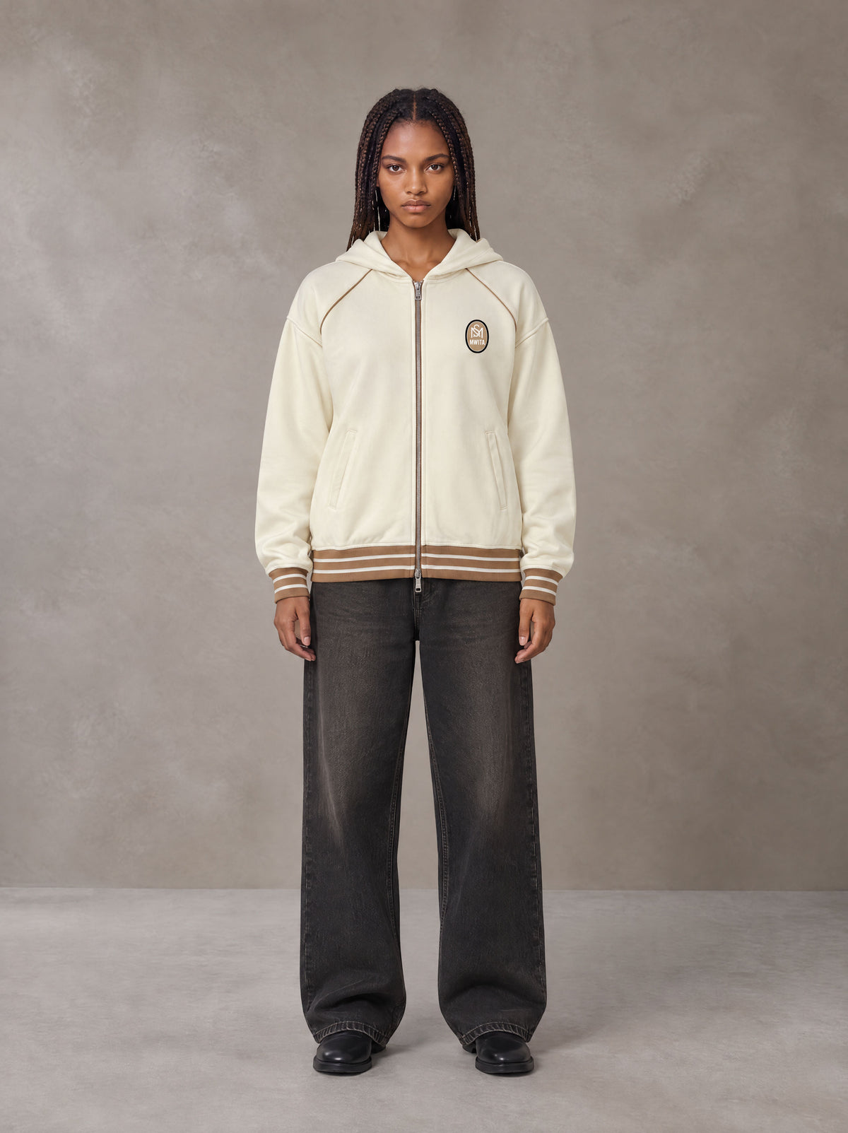 Model wearing the SM Insignia Hoodie in Soft Beige, front view.
