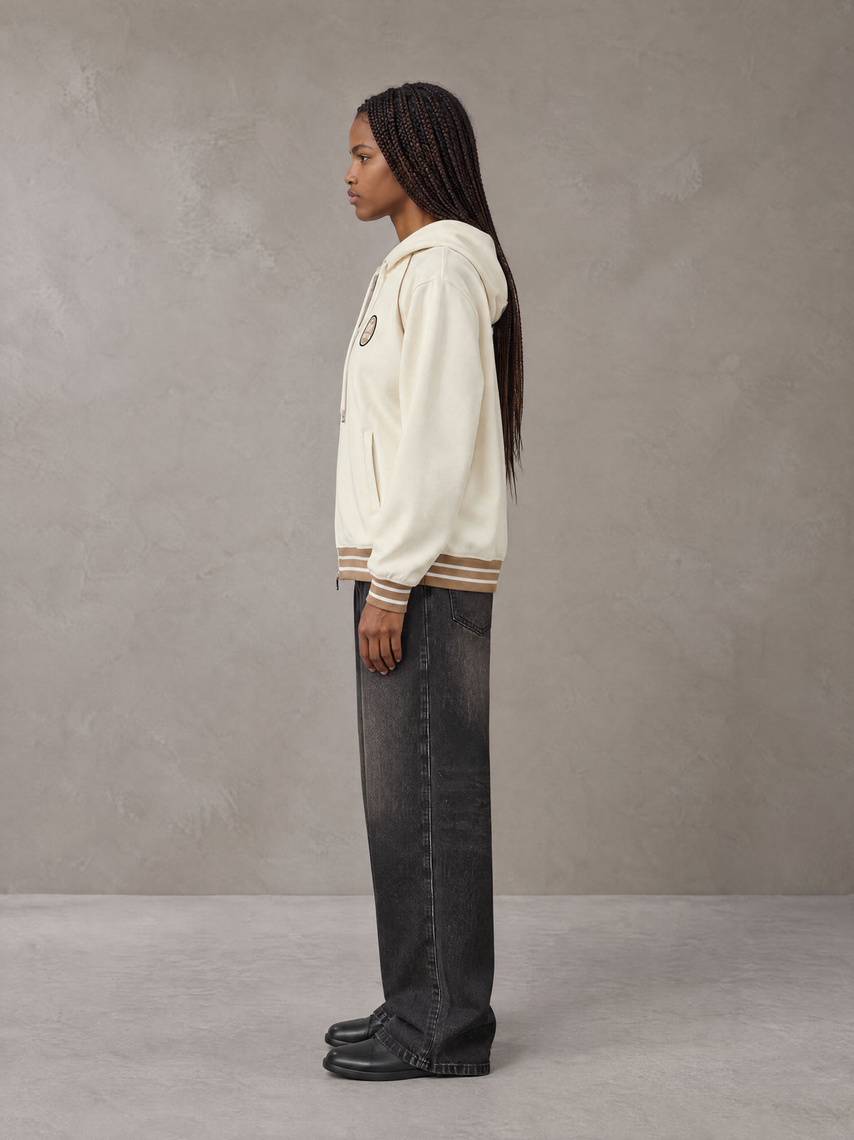 Model wearing the SM Insignia Hoodie in Soft Beige, side profile.