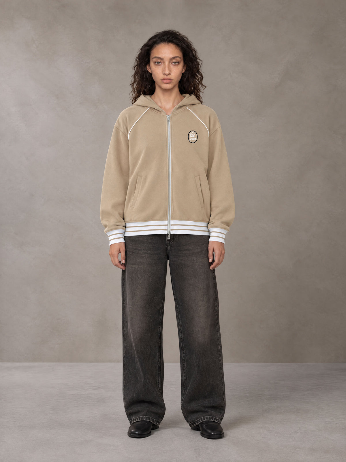Model wearing the SM Insignia Hoodie in Oatmeal Cookie, front view.