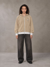 Model wearing the SM Insignia Hoodie in Oatmeal Cookie, front view.