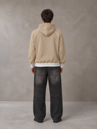 Model wearing the SM Insignia Hoodie in Oatmeal Cookie, rear view.