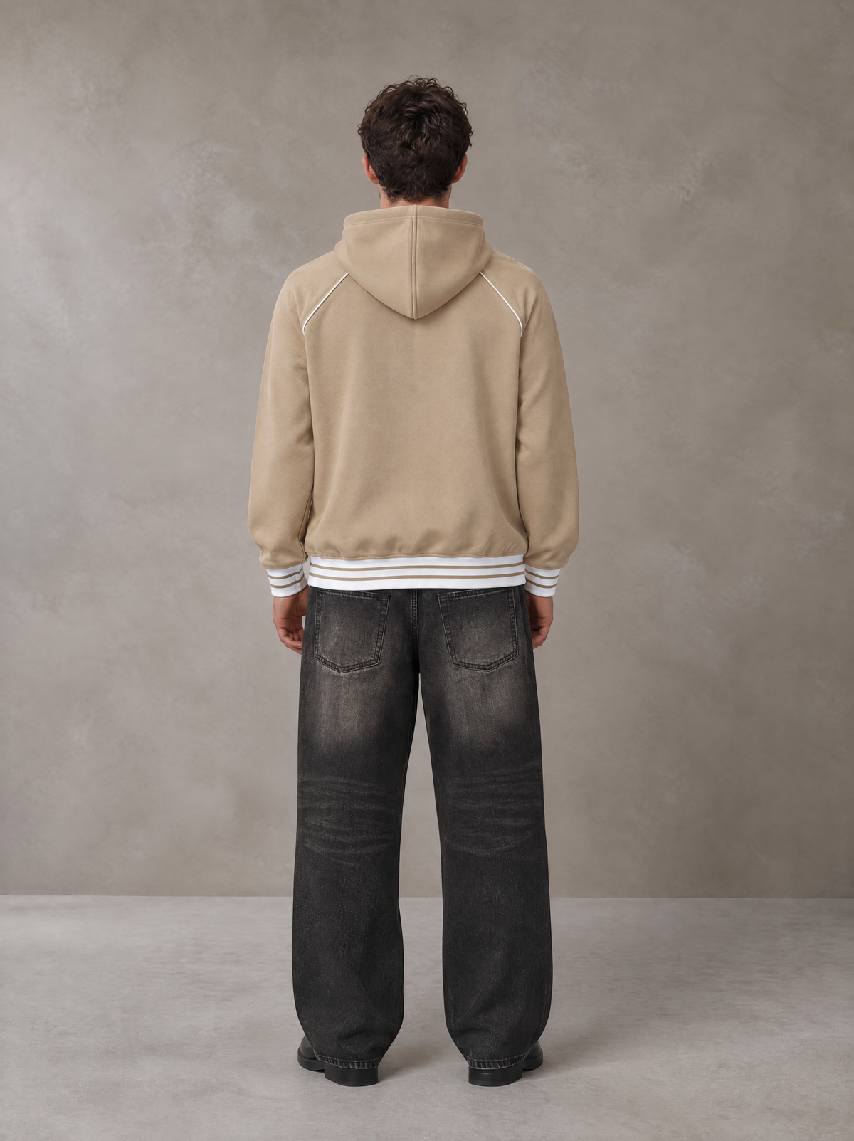 Model wearing the SM Insignia Hoodie in Oatmeal Cookie, rear view.