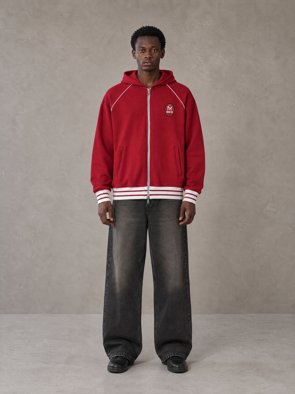 Model wearing the SM Insignia Hoodie in Carmine, front view.