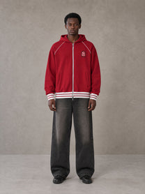 Model wearing the SM Insignia Hoodie in Carmine, front view.