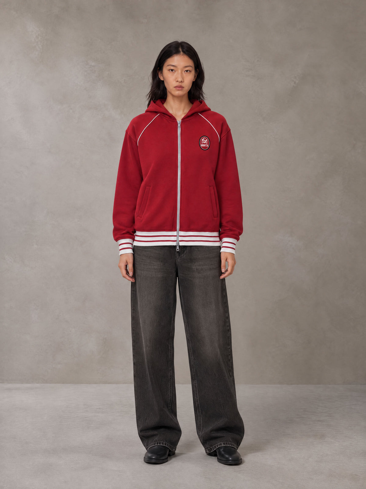 Model wearing the SM Insignia Hoodie in Carmine, front view.