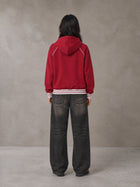 Model wearing the SM Insignia Hoodie in Carmine, rear view.