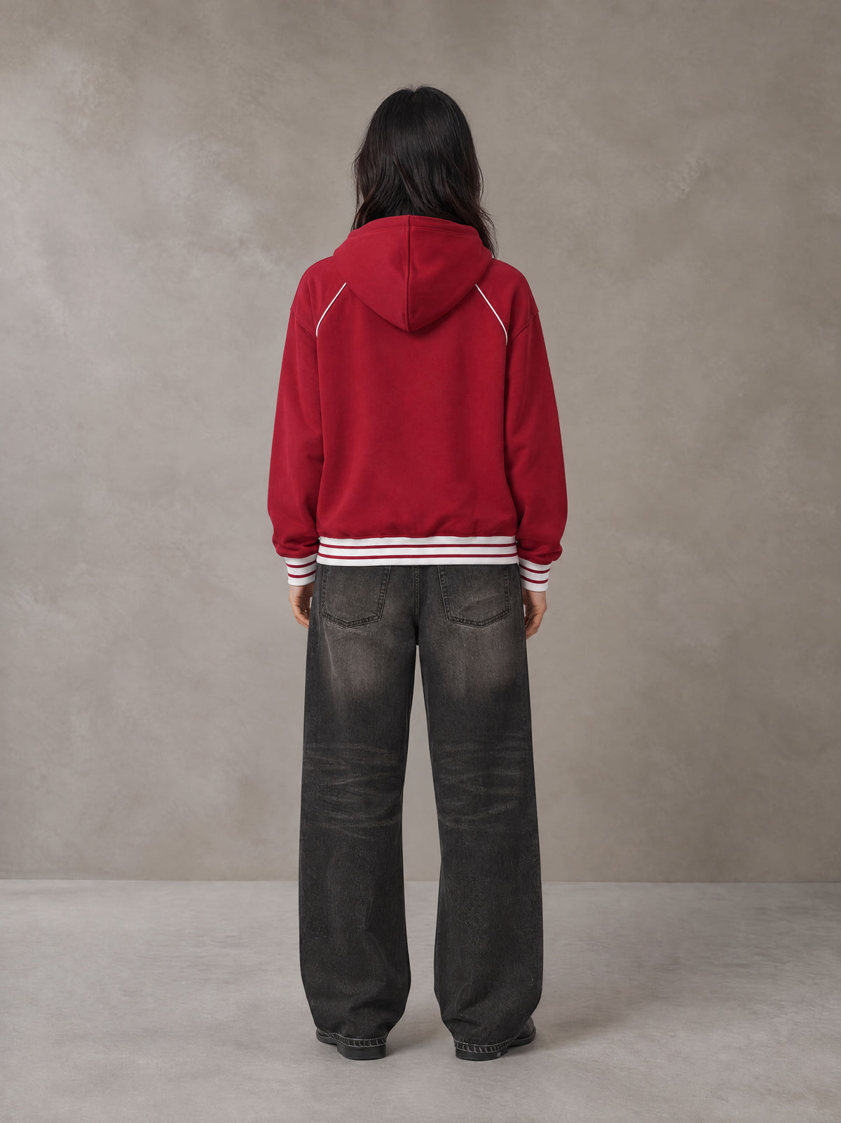 Model wearing the SM Insignia Hoodie in Carmine, rear view.