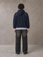 Model wearing the SM Insignia Hoodie in Oxford Navy, rear view.