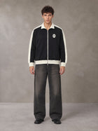 Model wearing the SM Insignia Jacket in Midnight Black, front view.