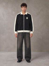 Model wearing the SM Insignia Jacket in Midnight Black, front view.