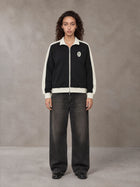 Model wearing the SM Insignia Jacket in Midnight Black, front view.