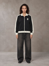 Model wearing the SM Insignia Jacket in Midnight Black, front view.