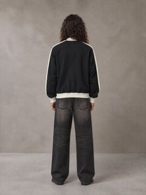 Model wearing the SM Insignia Jacket in Midnight Black, rear view.