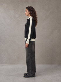 Model wearing the SM Insignia Jacket in Midnight Black, side profile.
