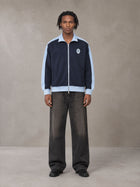 Model wearing the SM Insignia Jacket in Oxford Navy, front view.