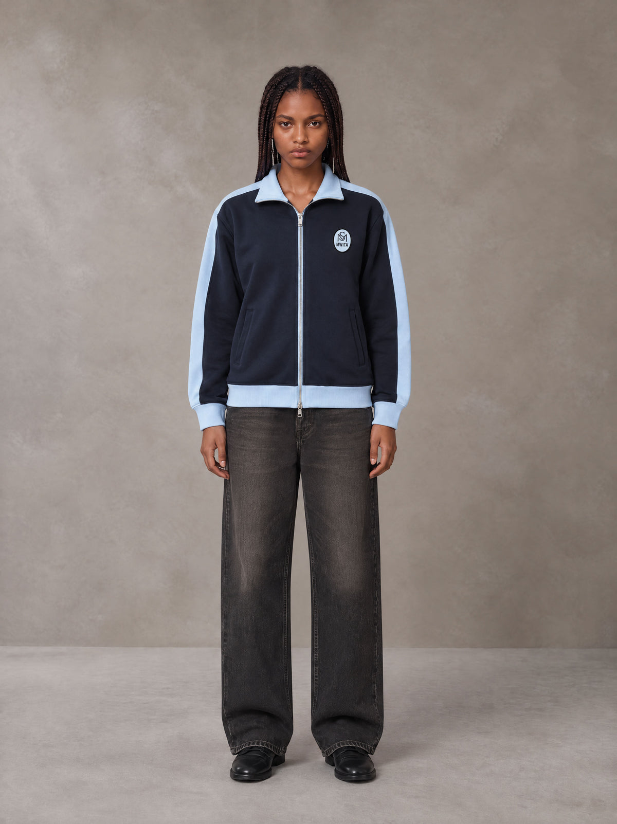 Model wearing the SM Insignia Jacket in Oxford Navy, front view.