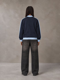 Model wearing the SM Insignia Jacket in Oxford Navy, rear view.