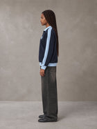Model wearing the SM Insignia Jacket in Oxford Navy, side profile.