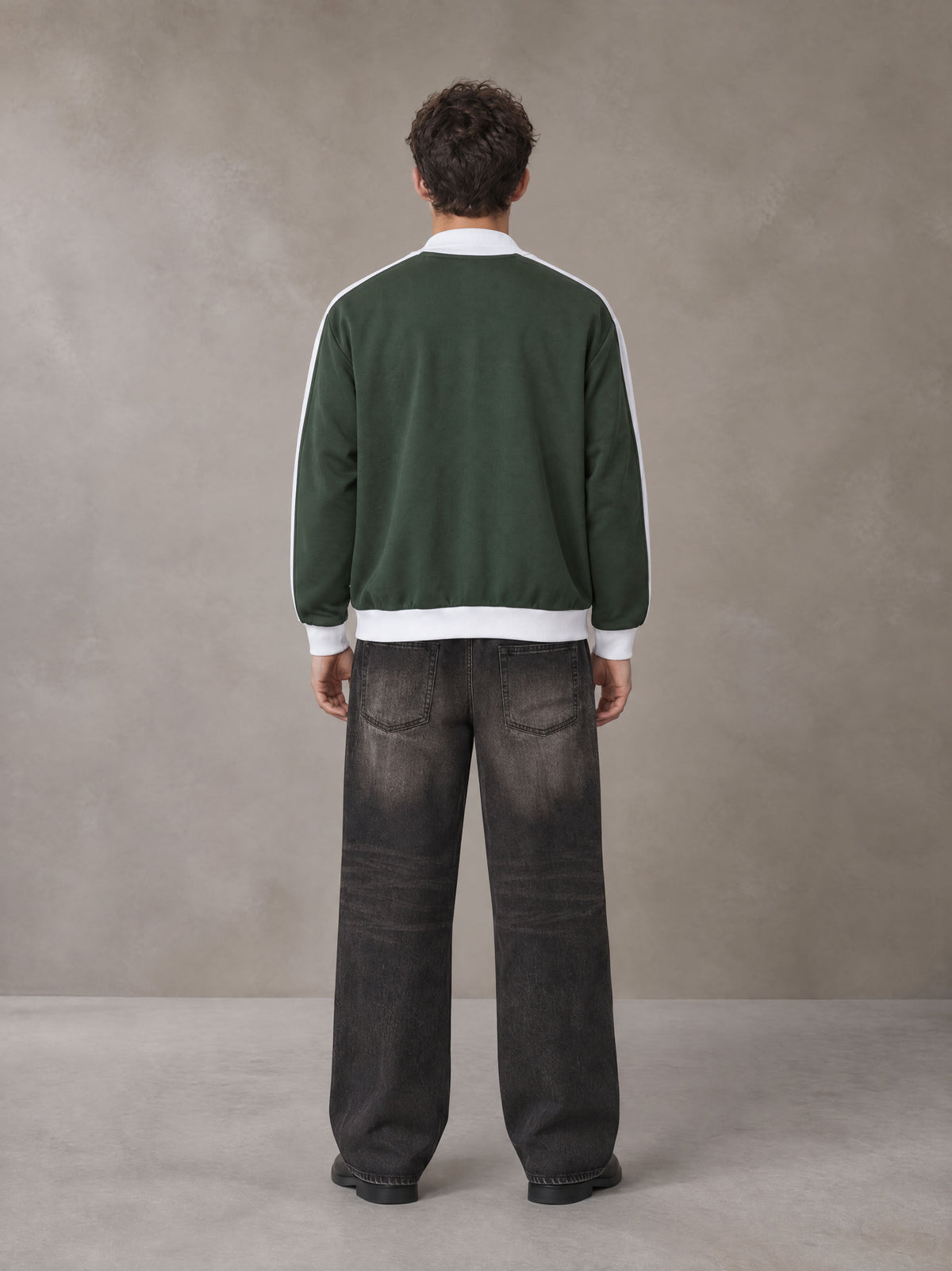 Model wearing the SM Insignia Jacket in Olive Shade, rear view.