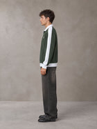 Model wearing the SM Insignia Jacket in Olive Shade, side profile.