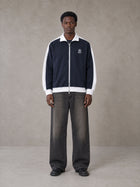 Model wearing the SM Insignia Jacket in Oxford Navy, front view.