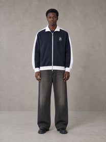 Model wearing the SM Insignia Jacket in Oxford Navy, front view.
